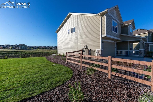 view of home's exterior with a garage and a lawn