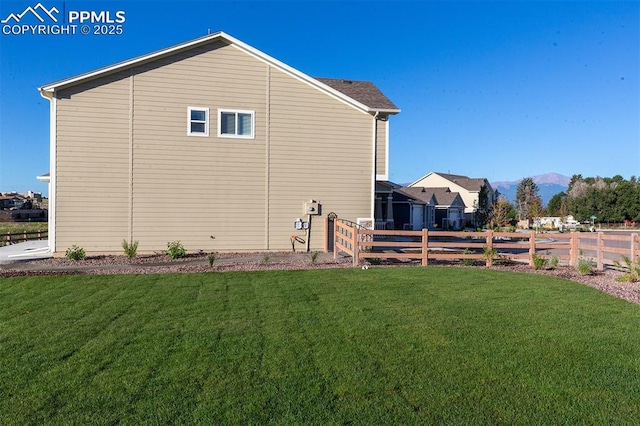 view of home's exterior with a mountain view and a yard