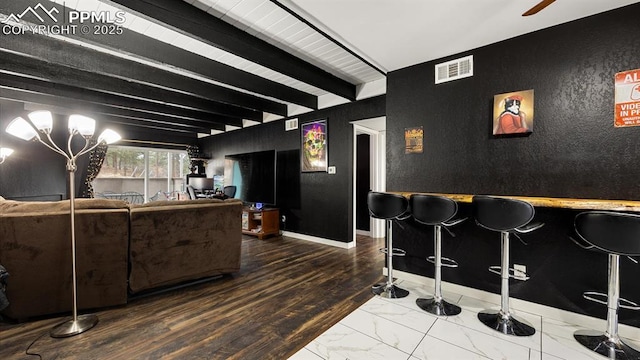 cinema featuring beamed ceiling and bar area