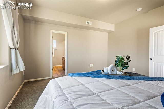 bedroom with ensuite bath and carpet flooring