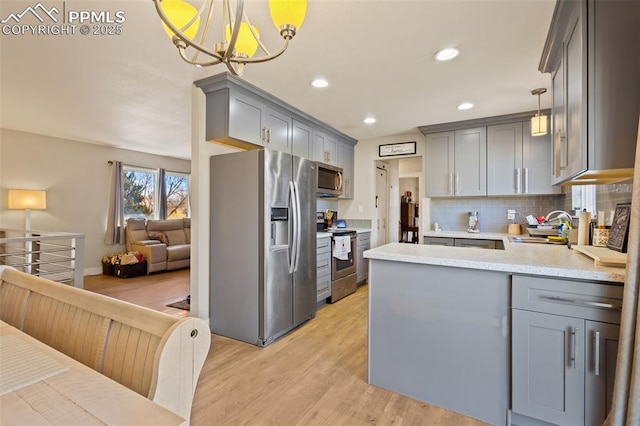 kitchen featuring appliances with stainless steel finishes, pendant lighting, and gray cabinets