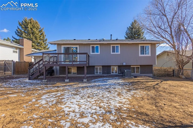 snow covered rear of property featuring a deck and central AC