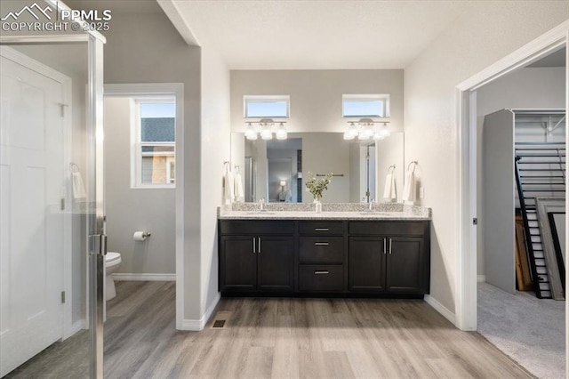 bathroom with toilet, vanity, and hardwood / wood-style floors