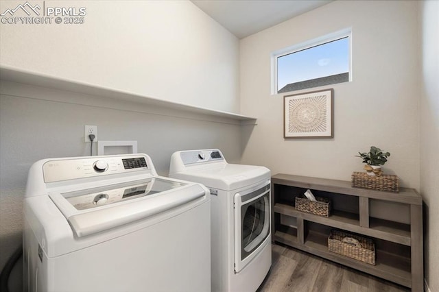 clothes washing area with washer and clothes dryer and dark hardwood / wood-style floors