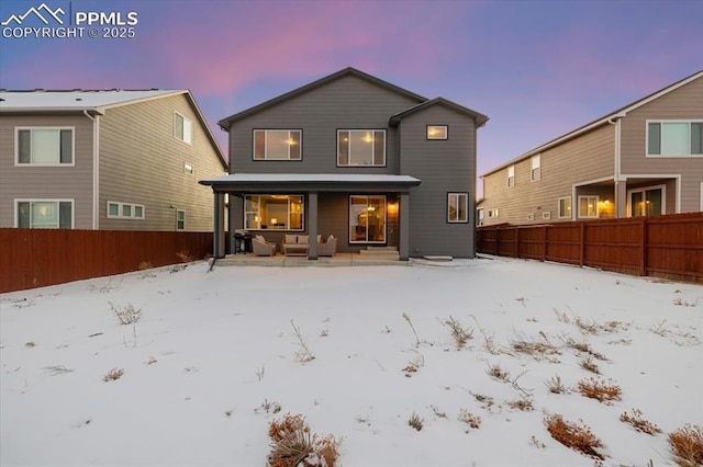 view of snow covered back of property