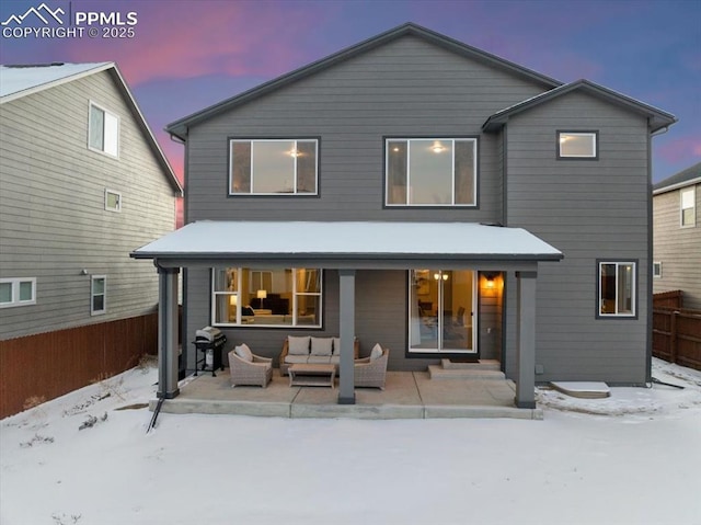 snow covered back of property featuring an outdoor hangout area