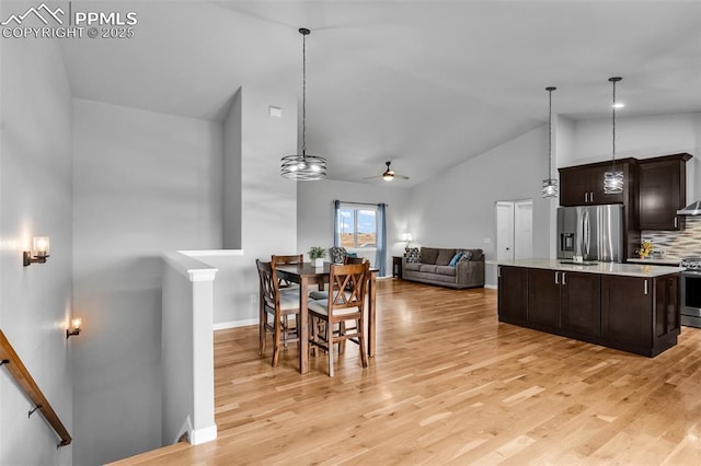 dining room with ceiling fan, light hardwood / wood-style floors, and lofted ceiling