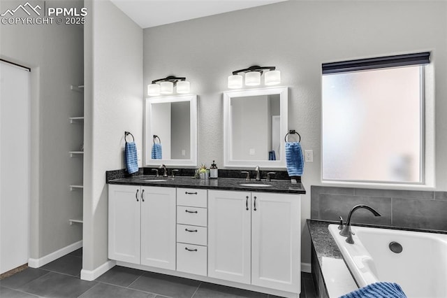 bathroom featuring tile patterned flooring, vanity, and a bathing tub