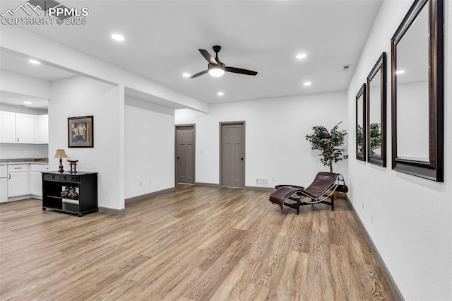 sitting room with light hardwood / wood-style floors and ceiling fan