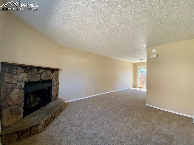 unfurnished living room featuring a stone fireplace, carpet, and a textured ceiling