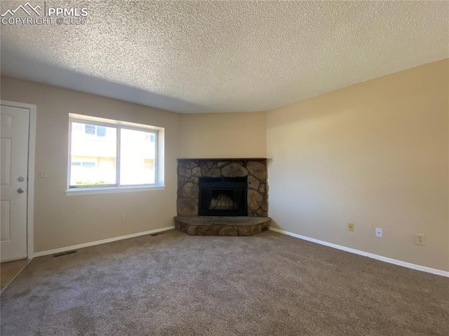 unfurnished living room with a fireplace, carpet floors, and a textured ceiling