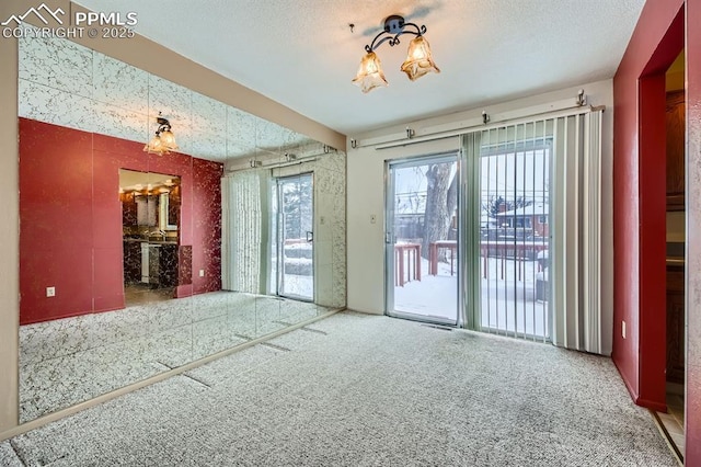 spare room featuring carpet floors and a textured ceiling