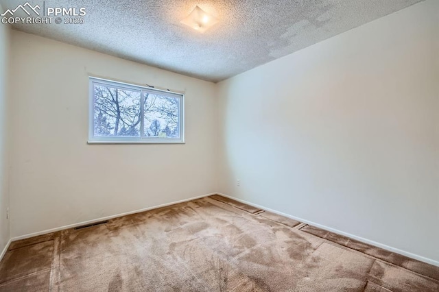 carpeted empty room with a textured ceiling