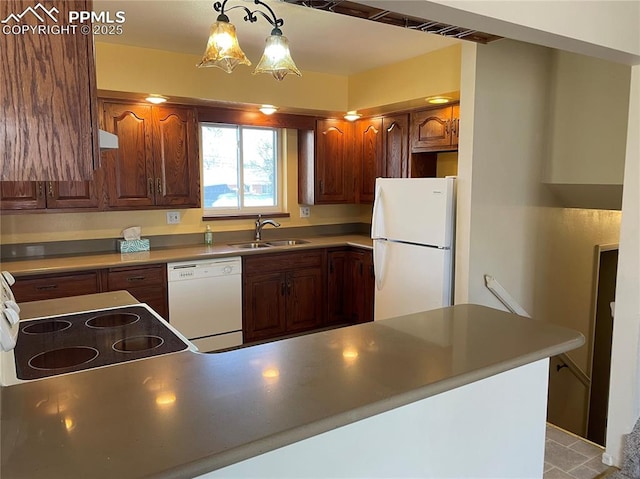 kitchen with sink, hanging light fixtures, and white appliances