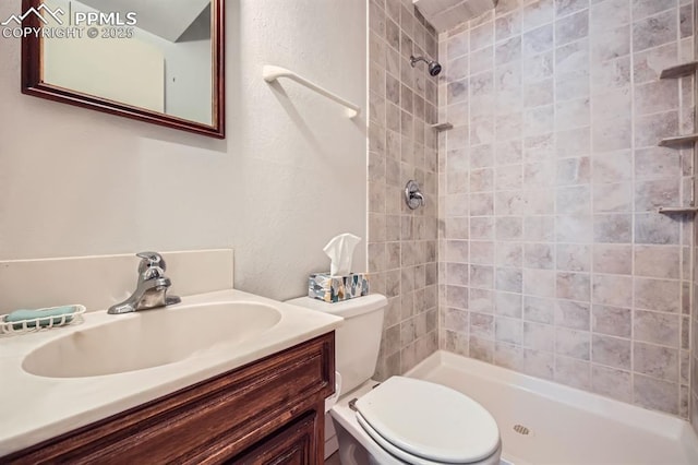 bathroom featuring vanity, tiled shower, and toilet