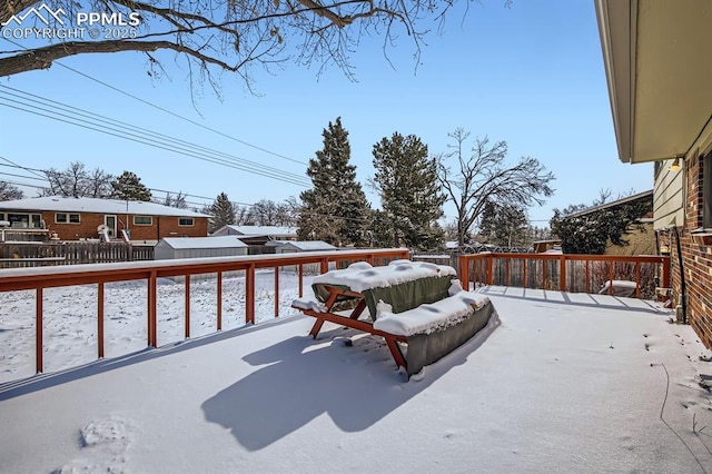 snow covered patio with a deck