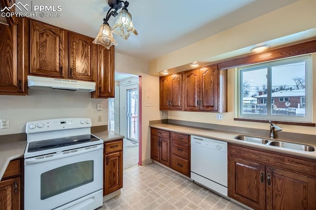 kitchen featuring hanging light fixtures, sink, and white appliances