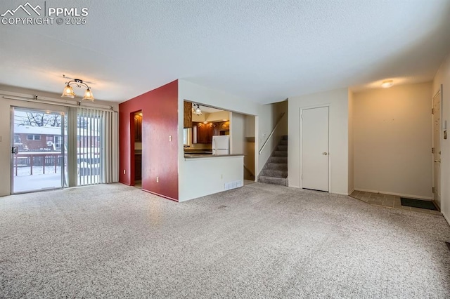 unfurnished living room with carpet and a textured ceiling