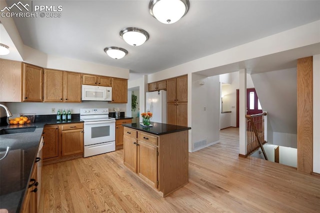 kitchen with sink, white appliances, light hardwood / wood-style floors, and a kitchen island