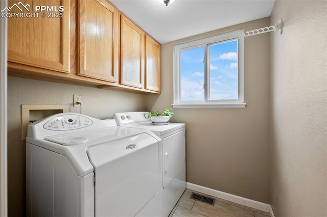 laundry room featuring cabinets, washer and dryer, and tile patterned floors