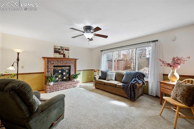 carpeted living room with ceiling fan and a fireplace