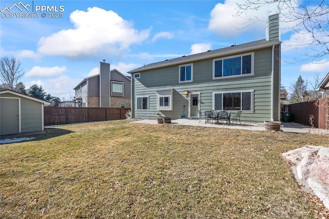 back of property with a shed, a yard, and a patio area