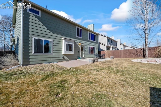 back of property with a lawn and a patio area