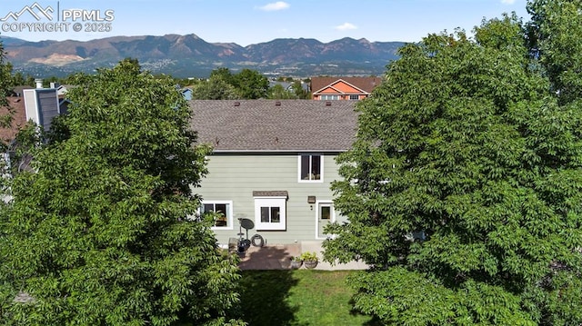 back of property with a patio, a mountain view, and a yard