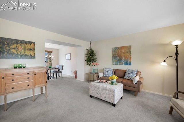 carpeted living room with a chandelier