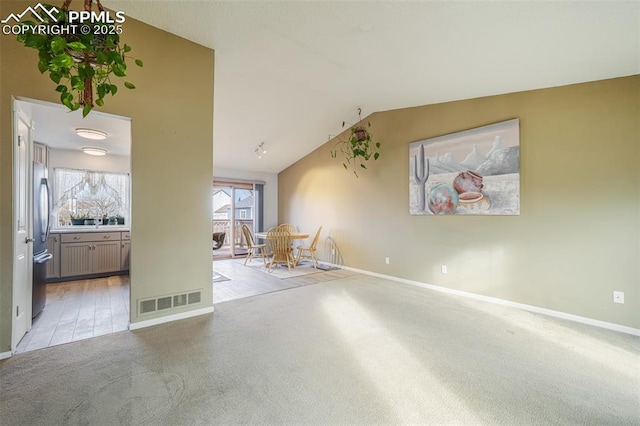 spare room with lofted ceiling and light carpet