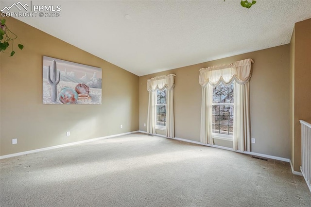 carpeted spare room with vaulted ceiling