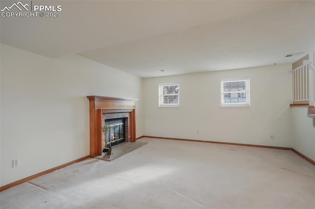 unfurnished living room with light carpet and a fireplace