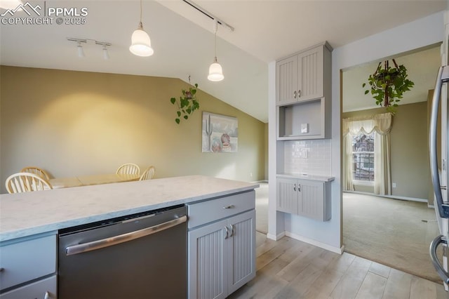 kitchen featuring gray cabinetry, light hardwood / wood-style flooring, stainless steel dishwasher, decorative light fixtures, and decorative backsplash