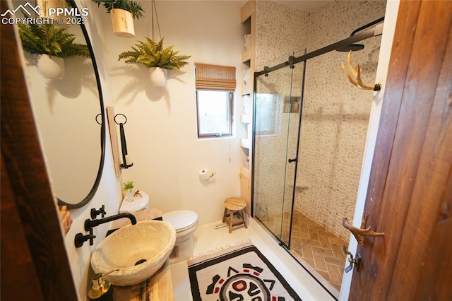 bathroom featuring tile patterned flooring, toilet, and a shower with door