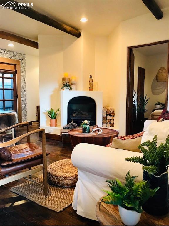 living area with hardwood / wood-style flooring and beamed ceiling