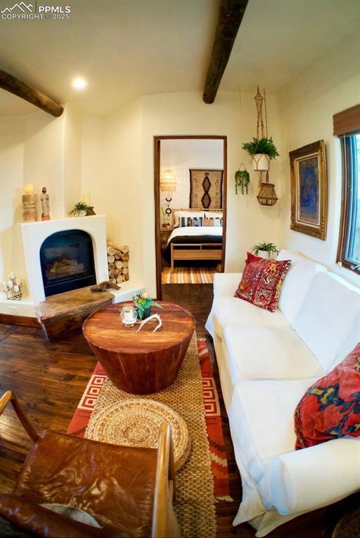 living room featuring dark hardwood / wood-style flooring and beamed ceiling