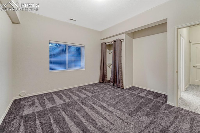 unfurnished bedroom with dark carpet