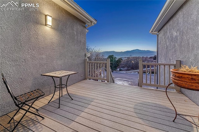 deck at dusk featuring a mountain view