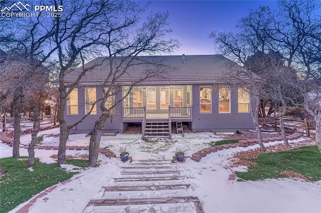 snow covered property with a deck