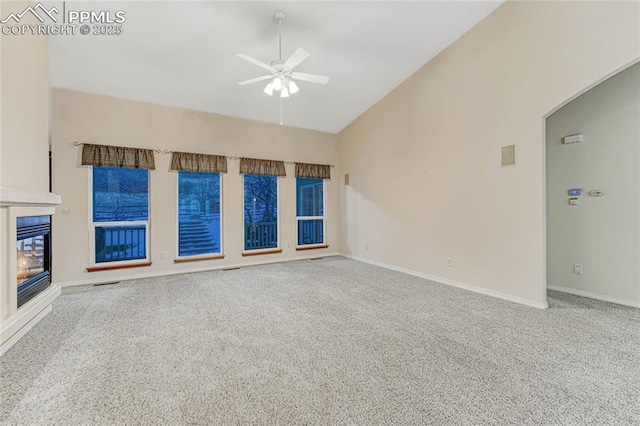 unfurnished living room featuring ceiling fan, high vaulted ceiling, and carpet floors