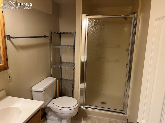 bathroom featuring tile patterned flooring, vanity, toilet, and a shower with shower door