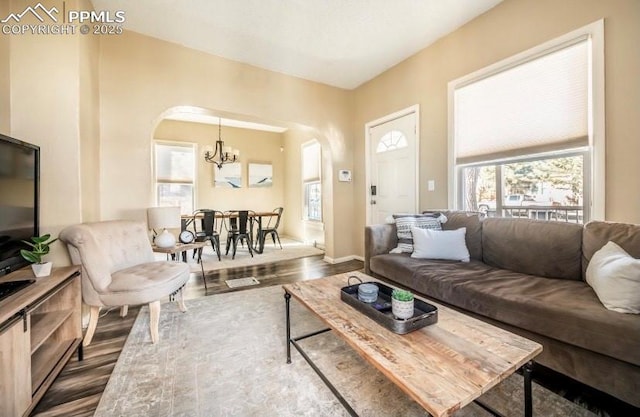 living room featuring a notable chandelier and dark wood-type flooring