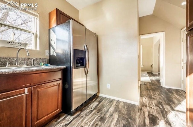 kitchen featuring vaulted ceiling, sink, dark hardwood / wood-style flooring, and stainless steel fridge with ice dispenser