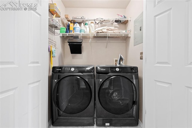 laundry area with electric panel and washing machine and clothes dryer