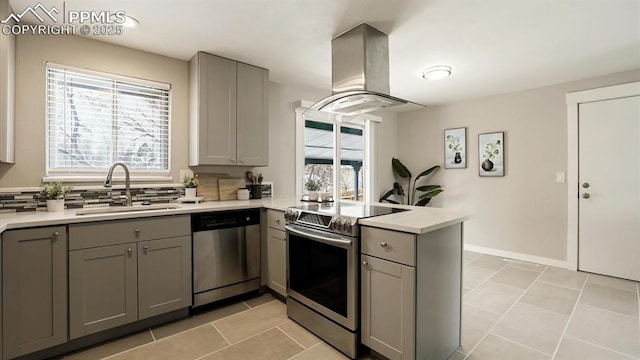 kitchen featuring island exhaust hood, appliances with stainless steel finishes, kitchen peninsula, sink, and gray cabinets