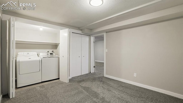 clothes washing area featuring washer and clothes dryer, carpet flooring, and a textured ceiling