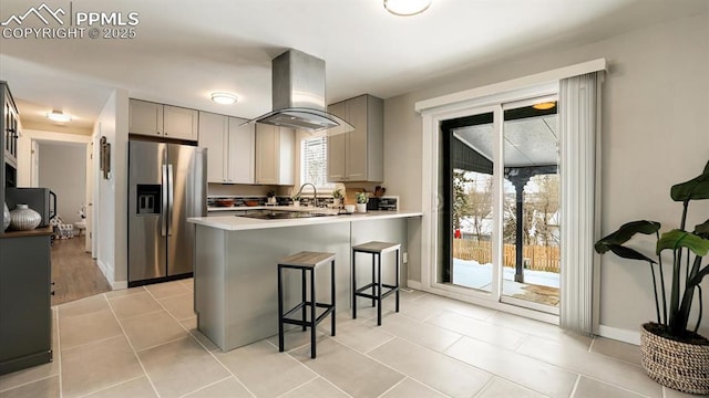 kitchen featuring gray cabinetry, stainless steel fridge, kitchen peninsula, and extractor fan