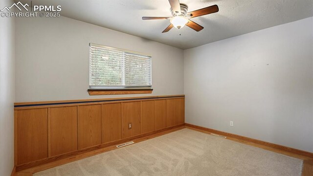 spare room featuring ceiling fan and light carpet