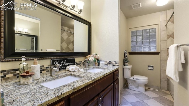 bathroom featuring vanity, a shower, toilet, and backsplash