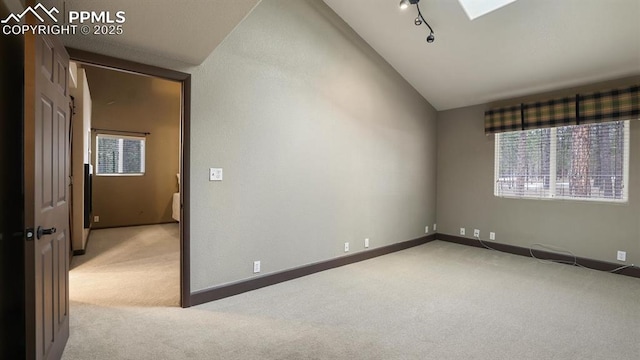 spare room with light carpet and vaulted ceiling